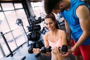 Professor ensinando exercício à aluna na gestão empresarial de academia