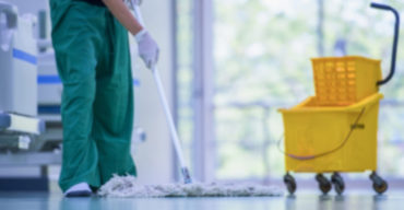 mulher limpando o chão mostrando a importância da limpeza profissional em clínicas