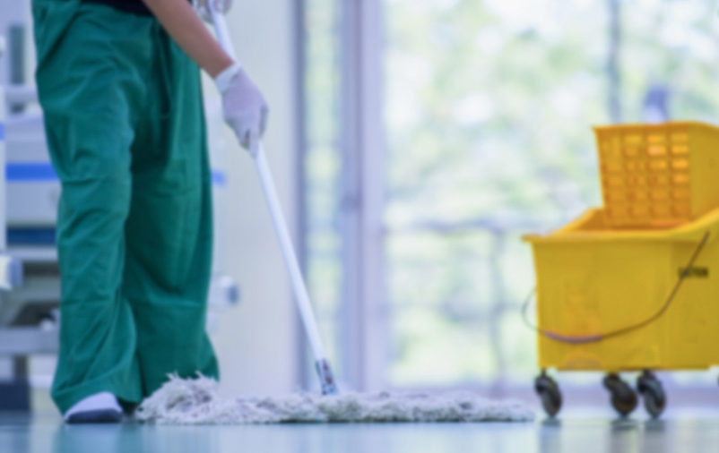 mulher limpando o chão mostrando a importância da limpeza profissional em clínicas