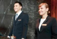 Saiba como reduzir rotatividade de funcionários com a terceirização Atendentes de hotel sorridentes ilustram estratégias para reduzir a rotatividade de equipe.
