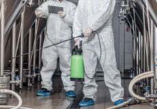 Entenda a importância da limpeza industrial profissional com a Whitening! Profissionais de macacão aplicam sanitizante em fábrica de limpeza industrial profissional.