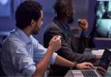 Tenha uma equipe especializada em terceirização de serviços empresariais Colaborador apontando para monitores durante operação de terceirização de serviços empresariais.