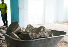 Saiba a importância da remoção de resíduos de obra Carrinho com concreto e destroços acumulados durante processo de remoção de resíduos de obra.