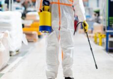 Sanitização de ambientes e planejamento da limpeza industrial com a Whitening Profissional equipado com proteção, em um corredor durante o planejamento da limpeza industrial.